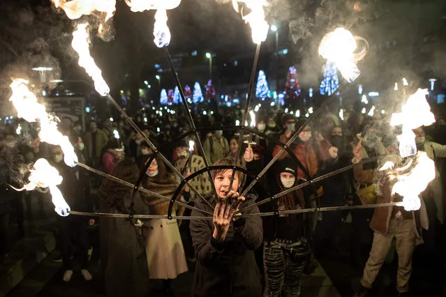 Protesters attend a torchlight procession to ask the reopening of the culture sector places in Nantes, France on December 15, 2020. (Photo by Loic Venance/AFP Photo)