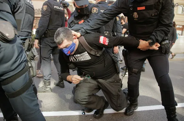 Police officers detain a man during a protest against the legislation which can bring partial privatisation of the public health sector in Madrid, Spain, February 27, 2021. (Photo by Javier Barbancho/Reuters)