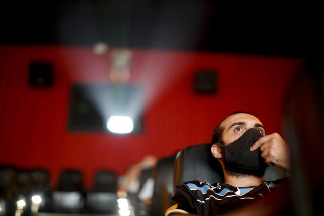 A man watches a movie at a cinema after almost a year of theaters being closed due to the COVID-19 pandemic, in Buenos Aires, Argentina, Wednesday, March 3, 2021. (Photo by Natacha Pisarenko/AP Photo)