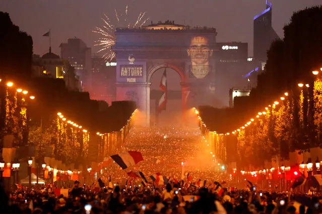 A giant picture of France's Antoine Griezmann is seen on the Arc de Triomphe in Paris, France on July 15, 2018, as France fans celebrate on the Champs-Elysees Avenue after France won the Soccer World Cup final. (Photo by Charles Platiau/Reuters)