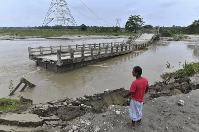 A man watches a bridge over the Motanga River washed away by flash floods following monsoon rains, in Ulubari village of Baska district, some 52 Km from Guwahati in India's Assam state on June 23, 2023. At least 19 people are dead after floods triggered by South Asia's annual monsoon, with a week of relentless rains forcing thousands of people to seek shelter in India. (Photo by Biju Boro/AFP Photo)