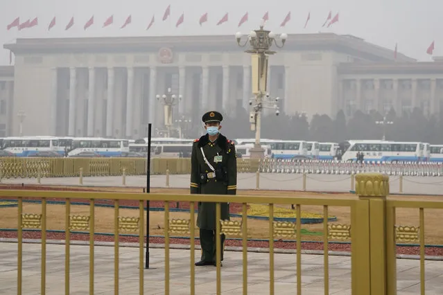 A Chinese paramilitary policeman stands watch near the Great Hall of the People where the annual National People's Congress is held in Beijing on Friday, March 5, 2021. The ruling Communist Party is aiming for economic growth “over 6%” as it rebounds from the coronavirus pandemic, Premier Li Keqiang said in a speech at China's ceremonial legislature Friday. (Photo by Ng Han Guan/AP Photo)
