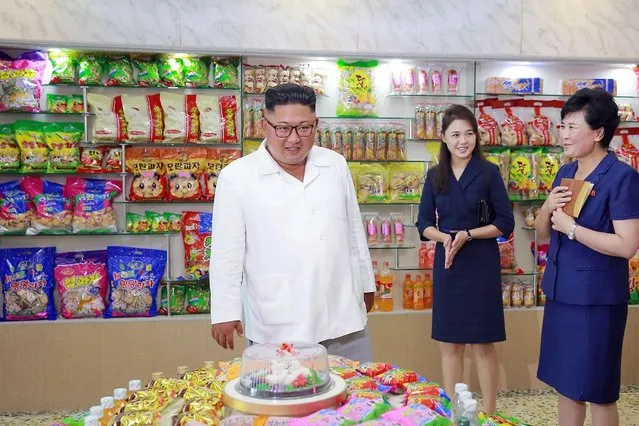 This undated picture released by North Korea' s official Korean Central News Agency (KCNA) on July 26, 2018 via KNS shows North Korean leader Kim Jong Un (C), accompanied by his wife Ri Sol Ju (2nd R), inspecting the Songdowon General Foodstuff Factory in Kangwon Province. (Photo by AFP Photo/KCNA via KNS)