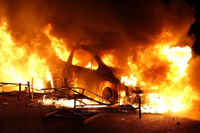 A vehicle burns, destroyed by protesters in Nanterre, west of Paris, on June 27, 2023, after French police killed a teenager who refused to stop for a traffic check in the city. The 17-year-old was in the Paris suburb early on June 27 when police shot him dead after he broke road rules and failed to stop, prosecutors said. The event has prompted expressions of shock and questions over the readiness of security forces to pull the trigger. (Photo by Zakaria Abdelkafi/AFP Photo)