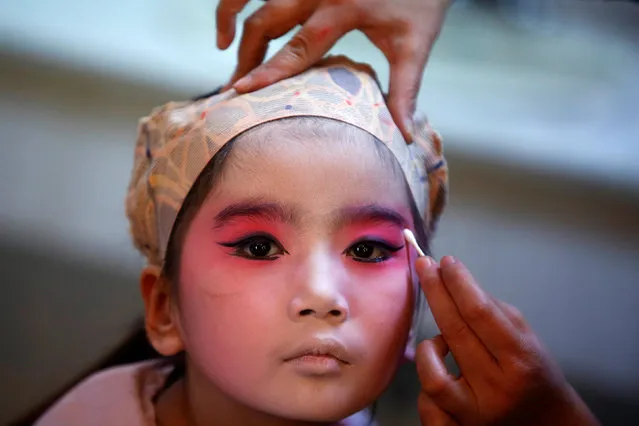 A participant has her make-up done during a traditional Chinese opera competition at the National Academy of Chinese Theatre Arts in Beijing, China, November 26, 2016. (Photo by Thomas Peter/Reuters)