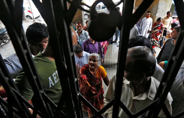 A woman talks to a man as she stands in a queue to deposit or exchange her old high denomination banknotes outside a bank in Kolkata, India, November 21, 2016. (Photo by Rupak De Chowdhuri/Reuters)