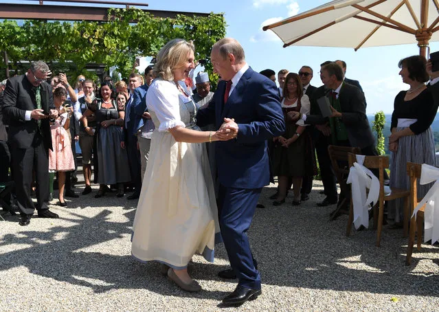 Russian President Vladimir Putin, right, congratulates Austrian Foreign Minister Karin Kneissl as he attends the wedding of Kneissl with with Austrian businessman Wolfgang Meilinger in Gamlitz, southern Austria, Saturday, Aug. 18, 2018. (Photo by Roland Schlager/Pool Photo via AP Photo)