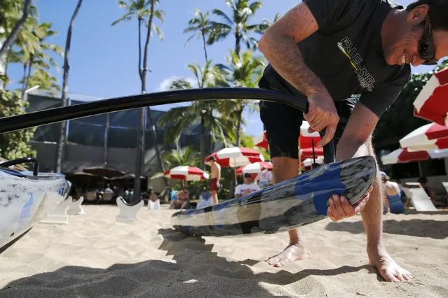 Johnny Puakea, whose father is a well-known craftsman of traditional Koa wood-hewn Hawaiian canoes, assembles one of his own sleek carbon-fiber outrigger canoe designs at the Outrigger Canoe Club in Honolulu, Hawaii January 1, 2016. (Photo by Jonathan Ernst/Reuters)