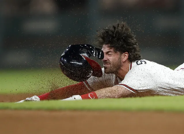 Atlanta Braves' Dansby Swanson slides into second base with a double during the seventh inning of the team's baseball game against the Philadelphia Phillies on Thursday, September 20, 2018, in Atlanta. (Photo by John Bazemore/AP Photo)