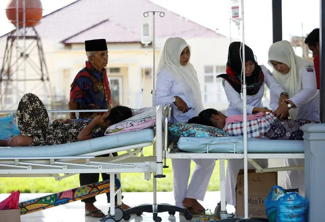 A patient is treated in the outdoor walkway, for saftey reasons, at a hospital after a strong earthquake in Meureudu, Pidie Jaya, Aceh province, Indonesia December 8, 2016. (Photo by Darren Whiteside/Reuters)