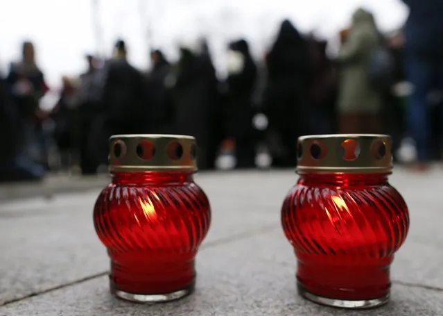 Lit candles are placed on the ground as people gather to attend a memorial service before the funeral of Russian leading opposition figure Boris Nemtsov in Moscow, March 3, 2015. Nemtsov's girlfriend has broken her public silence on the murder of the Russian opposition activist, saying she did not see the killer who gunned him down as they strolled across a bridge near the Kremlin. Anna Duritskaya, who is 23 or 24, said she had been under constant guard since the murder and would probably be unable to attend Nemtsov's funeral on Tuesday. REUTERS/Maxim Shemetov 