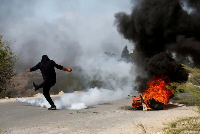 A Palestinian protestor kicks a tear-gas canister during clashes with the Israeli forces, near Tulkarm, in the Israeli-occupied West Bank on October 5, 2023. (Photo by Raneen Sawafta/Reuters)