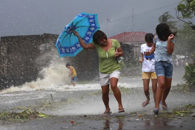 Residents walk along the coastal village while strong winds from Typhoon Haiyan battered Bayog town in Los Banos, Laguna, south of Manila November 8, 2013. (Photo by Charlie Saceda/Reuters)