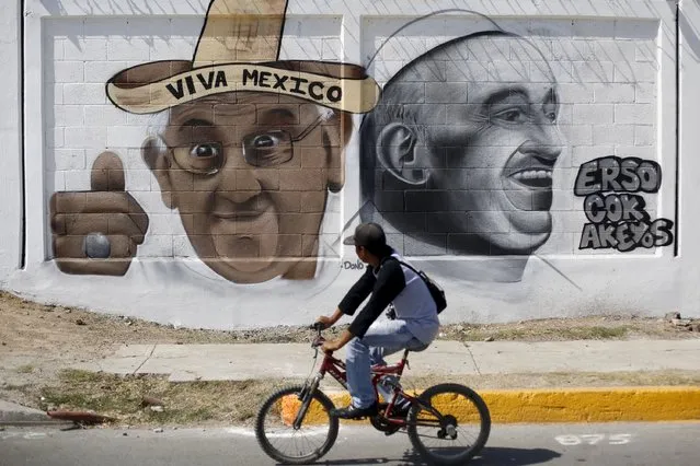 A rider cycles on his bicycle in front a graffiti of Pope Francis in Ecatepec, on the outskirts of Mexico City, Mexico, February 4, 2016. Pope Francis is scheduled to celebrate a mass in Ecatepec during his visit to Mexico City. (Photo by Edgard Garrido/Reuters)