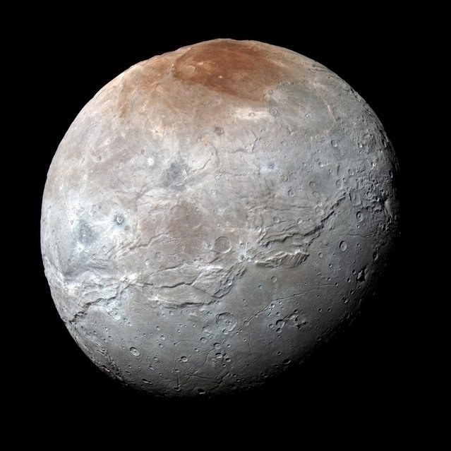 Pluto's largest moon, Charon, is seen in a high-resolution, enhanced color view captured by NASA's New Horizons spacecraft on July 14, 2015 and released September 15, 2016. Scientists have learned that reddish material in the north (top) polar region is chemically processed methane that escaped from Pluto's atmosphere onto Charon. (Photo by NASA/JHUAPL/SwRI)