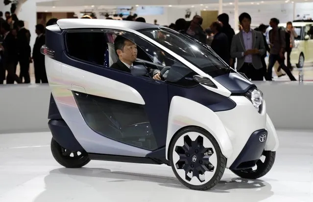 A visitor drives a three-wheeler Toyota i-ROAD electric concept car at the media preview for the Tokyo Motor Show at Tokyo Big Sight convention hall in Tokyo, Wednesday, November 20, 2013. (Photo by Shuji Kajiyama/AP Photo)
