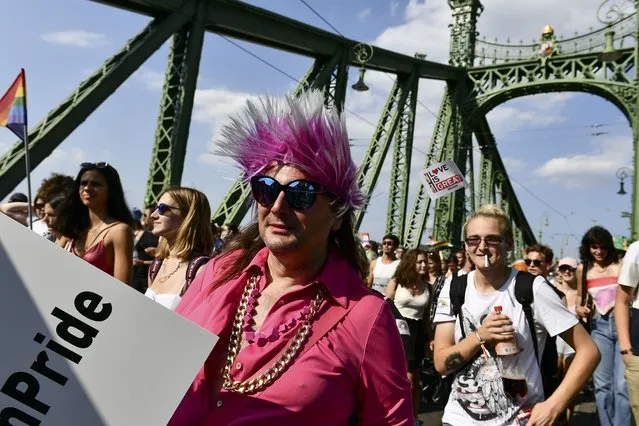 People march across the Szabadsag, or Freedom Bridge over the River Danube in downtown Budapest during a gay pride parade in Budapest, Hungary, Saturday, July 24, 2021. Rising anger over policies of Hungary's right-wing government filled the streets of the country's capital on Saturday as thousands of LGBT activists and supporters marched in the city's Pride parade. (Photo by Anna Szilagyi/AP Photo)