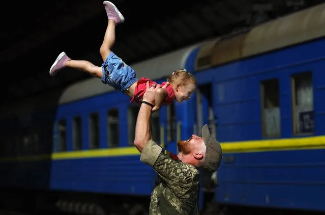 Ukrainian soldier Oleksandr lifts his two year old daughter Nikole after they disembarked a train from Zaporizhia at Lviv railway station on August 25, 2022 in Lviv, Ukraine. August 24 marked six months since Russia launched its large-scale invasion of Ukraine. Lviv has been spared the brunt of that attack, which has focused on central and eastern parts of Ukraine, but has been targeted periodically by missile strikes. (Photo by Jeff J. Mitchell/Getty Images)