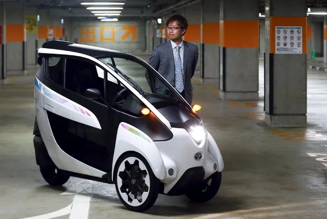 Toyota's i-Road chief engineer Akihiro Yanaka poses behind one of the electric vehicles that is to be used in a planned car sharing scheme in Tokyo April 9, 2015. (Photo by Thomas Peter/Reuters)