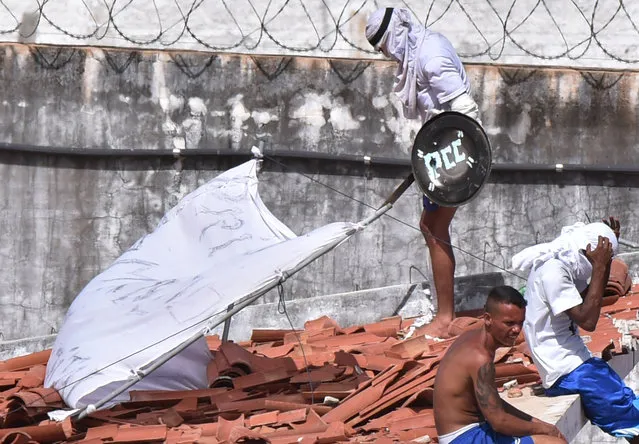 An inmate uses a shield with the initials PCC to protect himself after a new uprising broke out at Alcacuz prison in Natal, Rio Grande do Norte state, Brazil, January 16, 2017. PCC (First Command of the Capital), which are the Initials by Brazil's most powerful drug gang. (Photo by Josemar Goncalves/Reuters)