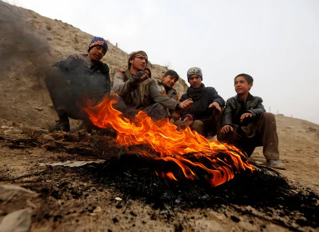 Afghan youth warm themselves by a fire during a cold day on the outskirts of Kabul, Afghanistan January 18, 2017. (Photo by Omar Sobhani/Reuters)