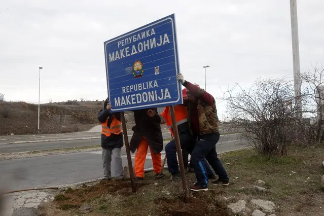 Workers remove a road sign that reads “Republic of Macedonia” in the southern border with Greece, near Gevgelija, Wednesday, February 13, 2019. The small Balkan country of Macedonia officially changed its name Tuesday by adding a geographic designation that ends a decades-old dispute with neighboring Greece and secures its entry into NATO. (Photo by Boris Grdanoski/AP Photo)