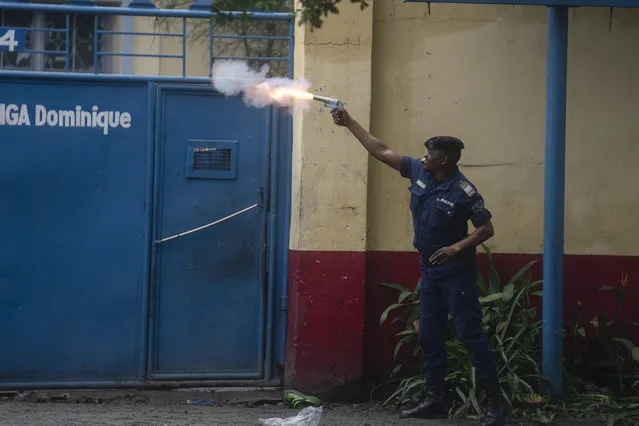 A member of security forces fires during clashes with supporters of presidential candidate Martin Fayulu outside his party's headquarters, in Kinshasa, Democratic Republic of the Congo, Wednesday, December 27, 2023. Fayulu, a main opposition candidate accused police of using live bullets to break up a protest Wednesday in Congo's capital, as demonstrators demanded a re-do for last week's presidential election. Fayulu is one of five opposition candidates who say the election should be rerun and question its credibility. Some rights groups and international observers also have questioned the vote. (Photo by Mosa'ab Elshamy/AP Photo)