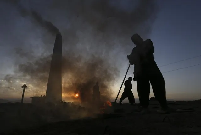 Afghan day laborers work at a brick factory as the sun sets, on the outskirts of Kabul, Afghanistan, Monday, April 20, 2015. (Photo by Rahmat Gul/AP Photo)