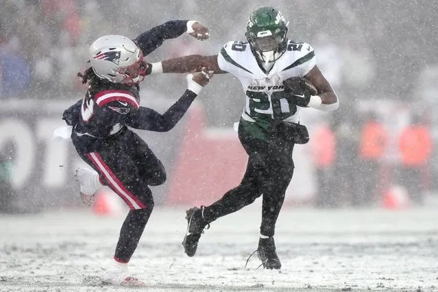 New York Jets running back Breece Hall (20) pushes away New England Patriots safety Kyle Dugger on a run during the first half of an NFL football game, Sunday, January 7, 2024, in Foxborough, Mass. (Photo by Steven Senne/AP Photo)