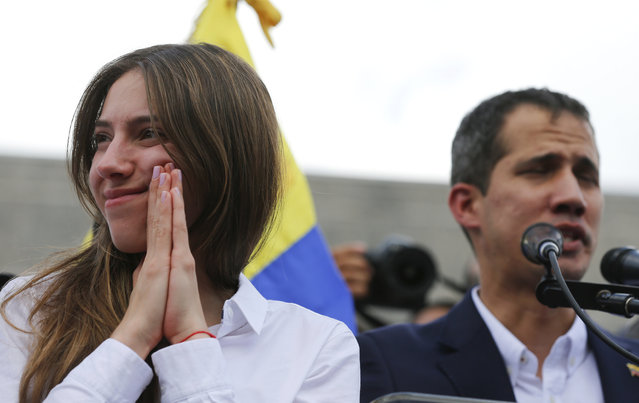 Fabiana Rosales, the wife of Venezuelan Congress President Juan Guaido, an opposition leader who declared himself interim president, gestures as her husband, right, addresses supporters during a rally demanding the resignation of Venezuelan President Nicolas Maduro in Caracas, Venezuela, Monday, March 4, 2019. The United States and about 50 other countries recognize Guaido as the rightful president of Venezuela, while Maduro says he is the target of a U.S.-backed coup plot. (Photo by Fernando Llano/AP Photo)