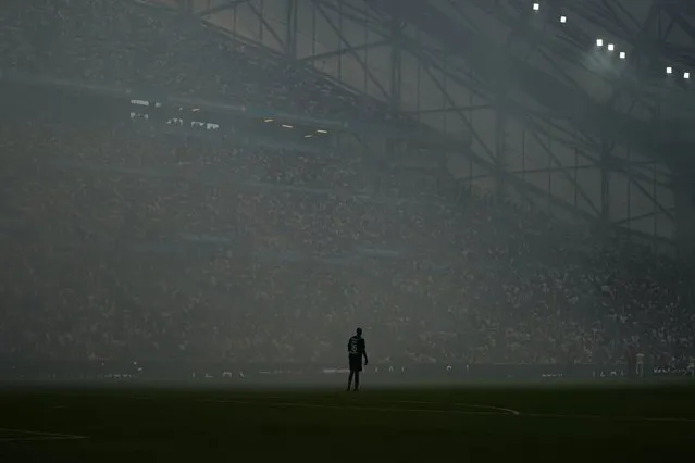 Rennes' goalkeeper Alfred Gomis stands through heavy fog caused by flares after Marseille's Amine Harit scores his side's second goal during the French League One soccer match between Marseille and Rennes at the Velodrome stadium in Marseille, France, Sunday, September 19, 2021. (Photo by Daniel Cole/AP Photo)