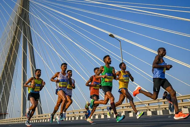 Participants run on Bandra-Worli sea link bridge as they take part in the 'Tata Mumbai Marathon' in Mumbai on January 21, 2024. (Photo by Punit Paranjpe/AFP Photo)