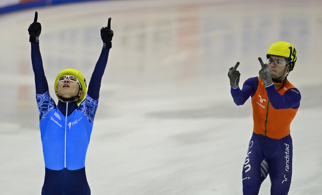 Sjinkie Knegt (R) of the Netherlands' team gestures next to Victor An (L) of the team of Russia celebrating after Russia won the men's 5000m relay final race of the ISU European Short Track speed skating Championships in Dresden, eastern Germany, on January 19, 2014. Russia won the race ahead of the Netherlands (2nd) and Germany. (Photo by Robert Michael/AFP Photo)