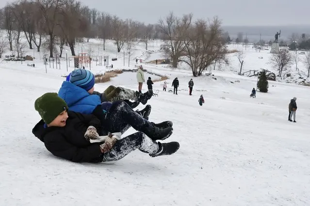 Children are seen sledding from a snow hill at a city park in Zaporizhzhia on January 11, 2024. Ukraine's children and their families have endured 23 months of forced displacement, unthinkable loss, and relentless violence since the escalation of war in February 2022. Since the beginning of the full-scale war in Ukraine, children have become one of the most vulnerable groups of the population. One of the most tangible effects of war on children is the loss of parents and friends. Many children are left orphaned or forced to live in devastated conditions. (Photo by Andriy Andriyenko/SOPA Images/Rex Features/Shutterstock)