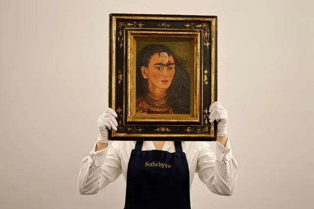 An assistant displays the artwork entitled Diego y yo (Diego and I) by Mexican painter Frida Kahlo at Sotheby's auction house in central London on October 21, 2021. (Photo by Tolga Akmen/AFP Photo)