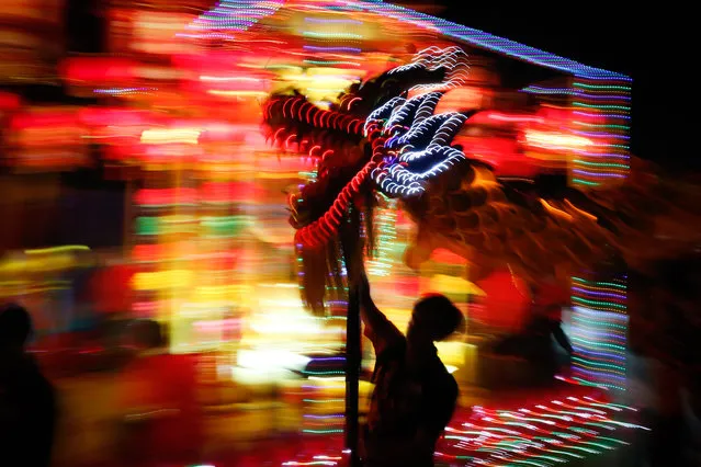 Performers take part in a dragon dance during a night parade to celebrate Chinese New Year in Kuala Lumpur, Malaysia, Sunday, February 9, 2014. The Lunar New Year this year marks the Year of the Horse in the Chinese calendar. (Photo by Vincent Thian/AP Photo)