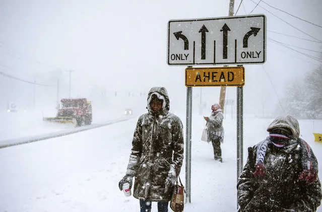 Charville Smith, left, Judy Simmons, center, and Cheryl Rosa stand at a Silver Lane bus stop, waiting for their ride home, after receiving a phone call from their employer, Cabela's, that it was closing due a snowstorm Thursday, February 9, 2017, in East Hartford, Conn. (Photo by Mark Mirko/Hartford Courant via AP Photo)