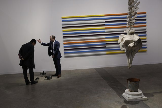 Two men chat next to an artwork “Whale” created by Irish artist Dorothy Cross during the VIP preview of the art fair “Art Basel” in Hong Kong, Tuesday, March 22, 2016. (Photo by Kin Cheung/AP Photo)