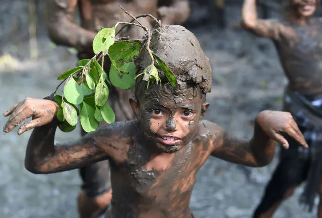 A Balinese boy puts mud on his body during a traditional mud bath known as Mebuug-buugan, in Kedonganan village, near Denpasar on Indonesia's resort island of Bali on March 8, 2019. The Mebuug-buugan is held a day after Nyepi aimed at neutralizing bad traits. (Photo by Sonny Tumbelaka/AFP Photo)