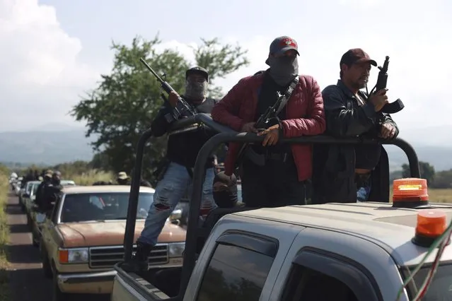 Members of the so-called self-defense group known as United Towns or Pueblos Unidos, gather for a rally in Nuevo Urecho, in the Mexican western state of Michoacan, Saturday November 27, 2021. Extortion of avocado growers in western Mexico has gotten so bad that 500 vigilantes from the “self-defense” group gathered Saturday and pledged to aid police. (Photo by Armando Solis/AP Photo)