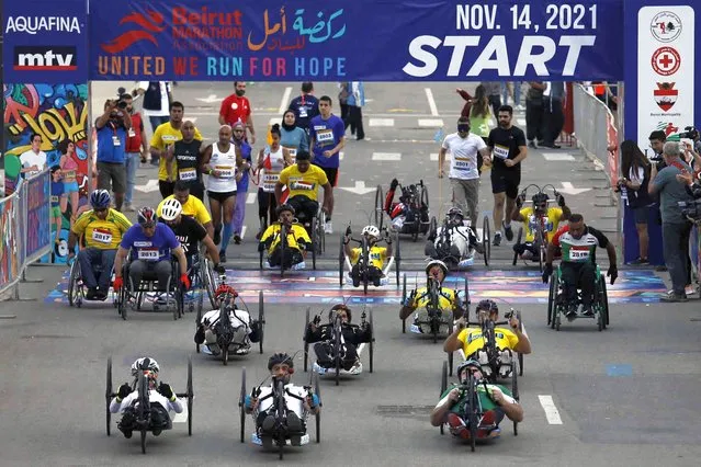 Wheelchair participants compete in the 42 kilometer (26 mile) Beirut International Marathon in Beirut, Lebanon, Sunday, November 14, 2021. Lebanon held its annual marathon for the first time after a two-year stop due to nationwide protests and the spread of coronavirus. (Photo by Bilal Hussein/AP Photo)