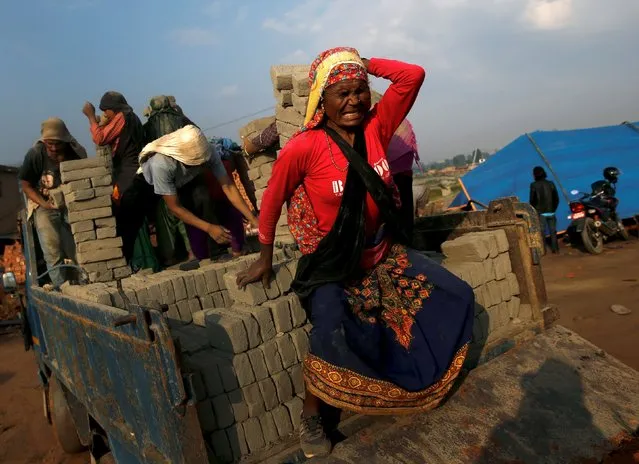 A woman tries to balance as she carries bricks on her back during work at a brick factory in Bhaktapur, Nepal, May 17, 2015. (Photo by Ahmad Masood/Reuters)