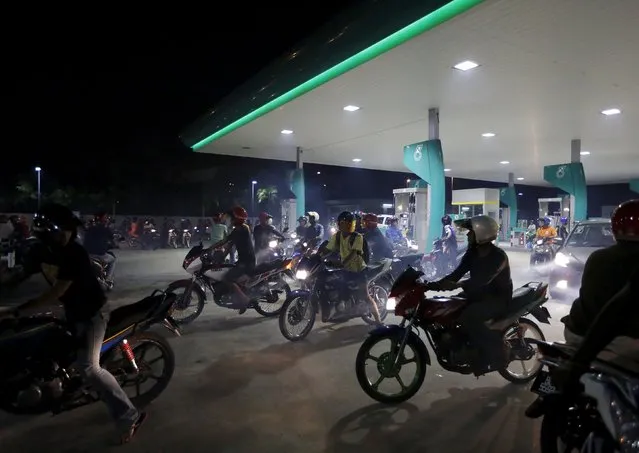 Motorcyclists gather at a petrol station on a highway where motorbike racing is taking place in Kuala Lumpur, Malaysia, Apri 19, 2015. (Photo by Olivia Harris/Reuters)