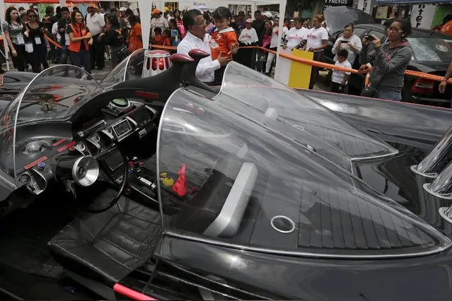 Valentin Gonzalez, mayoral candidate for the Citizen's Movement Party (Movimiento Ciudadano), carries a girl while standing next to a Batmobile replica in Nezahualcoyotl, on the outskirts of Mexico City, May 22, 2015. (Photo by Henry Romero/Reuters)