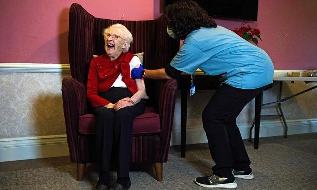 One hundred year-old Ellen Prosser, known as Nell, receives the Oxford/AstraZeneca COVID-19 vaccine from Dr Nikki Kanani at the Sunrise Care Home in Sidcup, south east London on January 7, 2021. A mass rollout by GP practices of the Oxford/AstraZeneca Covid-19 vaccine has begun, as hospitals across the United Kingdom face rising numbers of seriously ill patients. (Photo by Kirsty O'Connor/Pool via AFP Photo)
