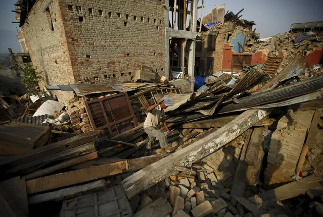 A man walks on the debris of collapsed houses, a month after the April 25 earthquake in Kathmandu, Nepal May 25, 2015. (Photo by Navesh Chitrakar/Reuters)