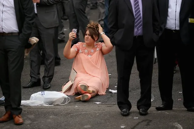 A racegoer uses the camera on her phone to check her hair on the opening day of the Grand National Festival at Aintree Racecourse on April 3, 2014 in Aintree, England. The three days of racing attracts thousands of racegoers and fans from across the world. The meeting culminates with millions of pounds being wagered on the runners taking part in Europe's richest jump race, the Grand National. (Photo by Christopher Furlong/Getty Images)