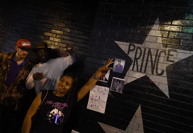 Fans pay their respects outside the First Avenue club where music legend Prince who has died suddenly at the age of 57, got his first breakthrough at the start of his musical career in Minneapolis, Minnesota, on April 22, 2016. His death came just a week after the enigmatic Grammy and Oscar winner – acclaimed for his guitar skills and soaring falsetto – was taken to a hospital with a flu-like illness that he later made light of. (Photo by Mark Ralston/AFP Photo)
