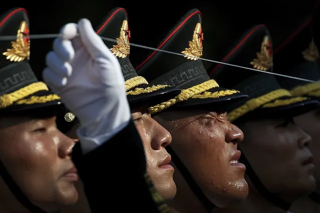 A member of an honor guard reacts as he and his comrades prepare for a welcome ceremony for visiting Colombia's President Ivan Duque, at the Great Hall of the People in Beijing, Wednesday, July 31, 2019. (Photo by Andy Wong/AP Photo)