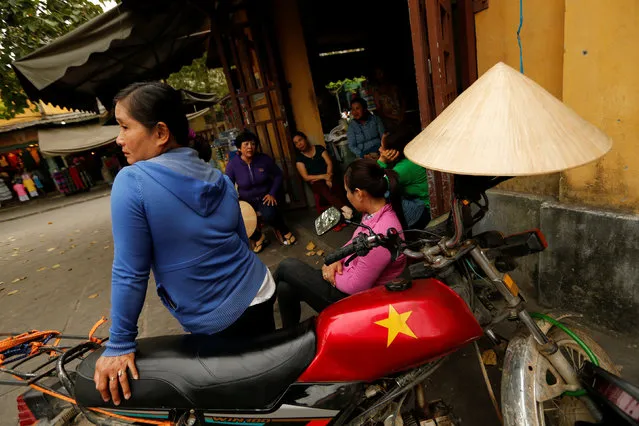 A woman sits on a motorcycle outside a market in Hoi An, Vietnam April 4, 2016. (Photo by Jorge Silva/Reuters)